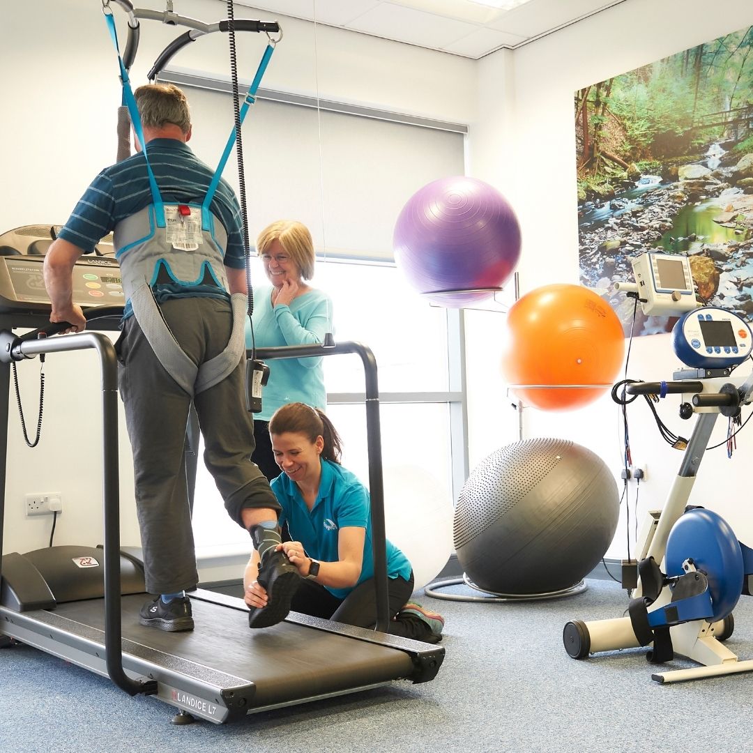 Physiotherapist supporting a client during bodyweight-supported treadmill training